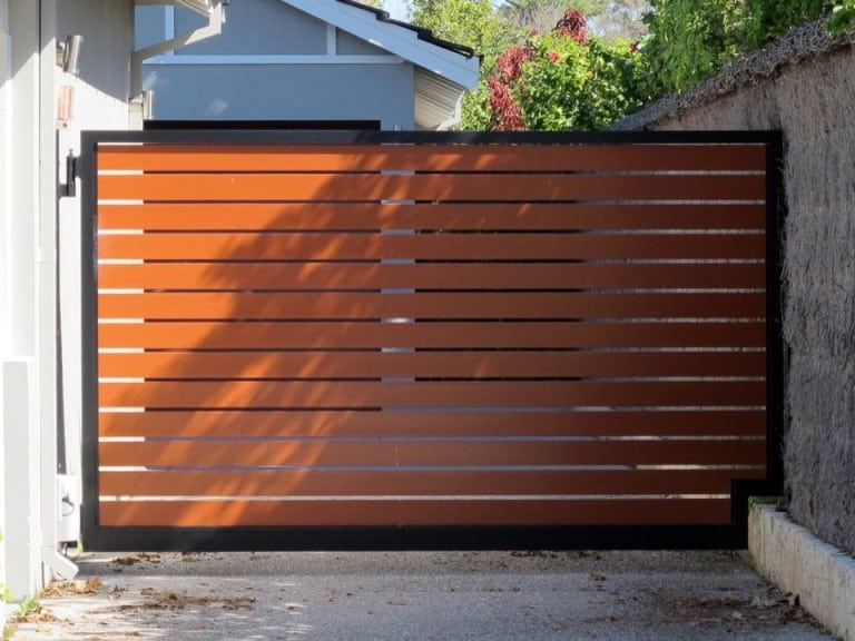 Wooden slat sliding driveway gate with a black metal frame for a modern look.