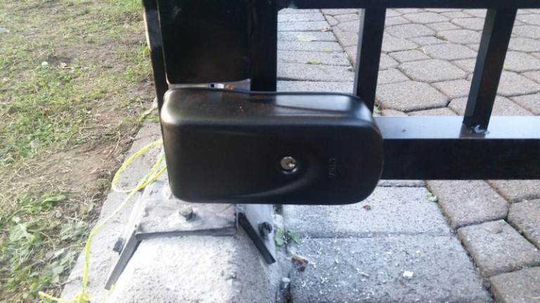 Metal doorway gate with a secure latch mechanism installed at the bottom for locking.